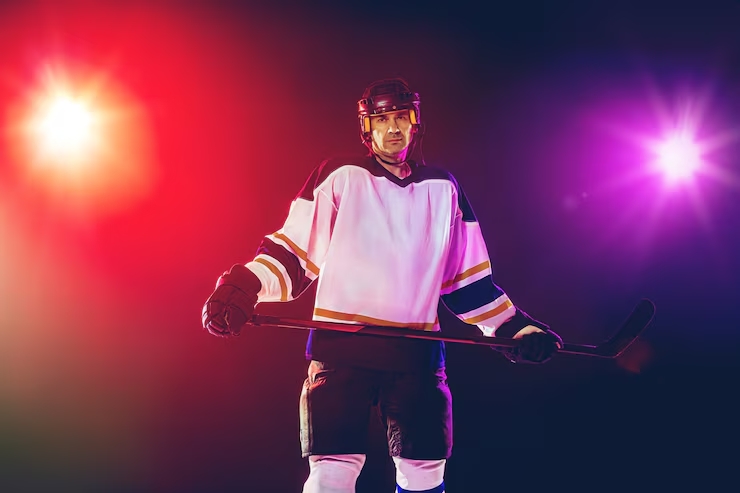 male-hockey-player-with-stick-ice-court-dark-neon-colored-wall_155003-31961